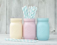 three pastel mason jars with straws in them