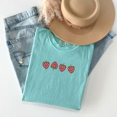 Welcome the sunny days with our delightful Summer Strawberry Embroidered T-Shirt! Made from 100% cotton, this t-shirt is not only comfortable but also perfect for staying cool during warm weather. Available in sizes S to 2XL and nine vibrant colors including Banana, Bay, Blossom, Butter, Chalky Mint, Chambray, Ivory, Orchid, and Peachy, there's a shade to suit every style.The standout feature of this t-shirt is the charming summer fruit-inspired design, showcasing four intricately embroidered strawberries on the center chest. Whether you're heading to a picnic, beach outing, or simply enjoying a leisurely day, this t-shirt adds a touch of sweetness to your summer wardrobe.Please note that colors may vary slightly due to monitor settings. For accurate sizing, refer to the size charts provid Embroidered Strawberries, Strawberry T Shirt, Beach Outing, Summer Apparel, Picnic Beach, Summer Fruit, Embroidered Tshirt, Size Charts, Summer Wardrobe