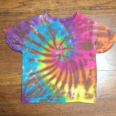 This dye was created on a size 2 100% Cotton Rabbit Skin tee. Hand Dyed Rainbow Top For Summer, Hand Dyed Rainbow Tops For Spring, Rainbow Hand Dyed Short Sleeve Tops, Rainbow Colored Hand Dyed Short Sleeve Tops, Casual Rainbow Hand-dyed Top, Casual Rainbow Hand Dyed Tops, Casual Hand Dyed Rainbow Top, Casual Hand-dyed Rainbow Top, Kids Graphic Tees