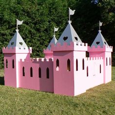 a pink castle with two flags on top