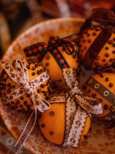 oranges decorated with ribbons and bows on a plate