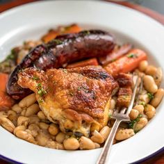 a white bowl filled with beans and meat