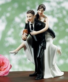 a bride and groom figurine sitting next to each other on top of a table