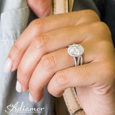 a close up of a person's hand with a diamond ring