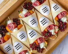 an assortment of fruit and cheese cones in a wooden box