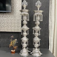 two silver candlesticks sitting on top of a table