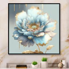 a large blue flower on a light blue background in front of a gold framed painting