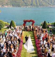 a bride and groom walking down the aisle to their wedding ceremony in front of an ocean view