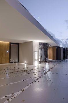 an empty room with white walls and floor covered in leaves on the ground at night