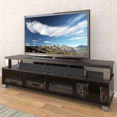 a flat screen tv sitting on top of a wooden entertainment center in a living room