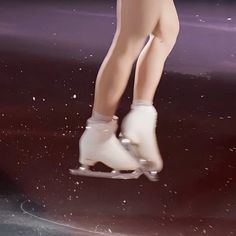 a woman in white boots is on a skateboard with snow flakes all around her