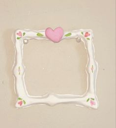 a white frame with a pink heart on it