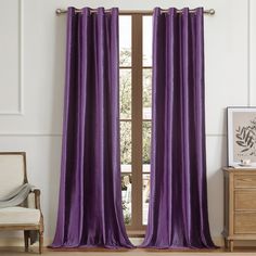 a purple curtain hanging in front of a window with a wooden chair and side table