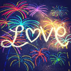 the word love written in chalk with fireworks