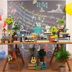 a table topped with lots of cake and flowers next to a chalkboard wall covered in writing