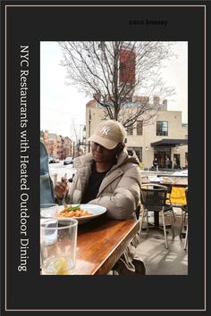 a woman sitting at a table with a plate of food in front of her on the street