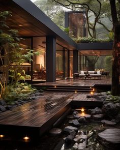 a modern house in the middle of a forest with lights on it's deck