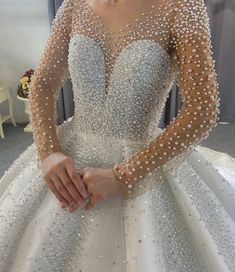 a woman in a white ball gown with pearls on the bouncy skirt and sleeves