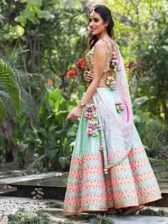 Our gorgeous rainbow mirror work choli has an open back with tassels. It is paired with an aqua lehenga skirt with tassels at the side. The outfit is completed with a net mukaish dupatta. Sangeet Lehengas, Lehenga Ideas, Sangeet Lehenga, Orang India, Designer Bridal Lehenga Choli, Raw Silk Lehenga, Mehendi Outfits, Sabyasachi Lehenga, Lehnga Dress