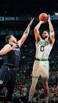 two men playing basketball in front of an audience