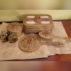 an assortment of antique items are displayed on a tablecloth, including a hair brush and comb