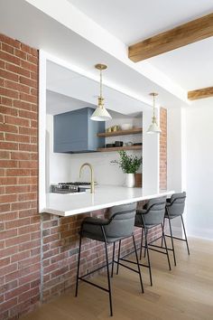 a kitchen with an island and bar stools in front of the countertop area