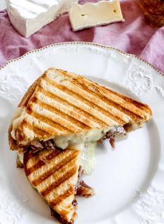 a grilled cheese sandwich sitting on top of a white plate