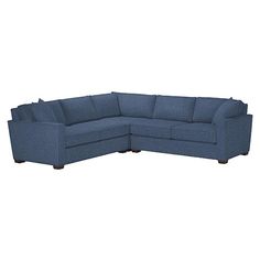 a blue sectional couch sitting on top of a white floor