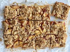 apple crumbled squares are arranged on top of parchment paper, ready to be baked