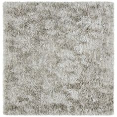 an area rug with grey and white shaggys on the top, in front of a white