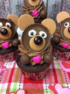 chocolate cupcakes decorated like mice with hearts and eyes on a checkered tablecloth