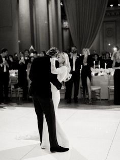 a bride and groom share their first dance at their wedding reception in the grand ballroom