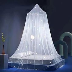 a bed with a blue canopy and white stars on the top, in a dark room