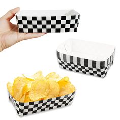 a hand is holding up two boxes of potato chips, one in black and white checkered paper