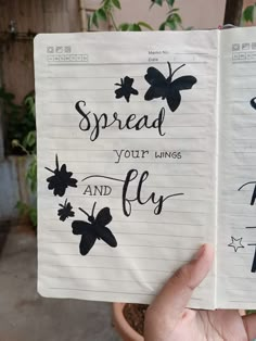 someone holding up a notebook with writing on it that says spread your wings and fly