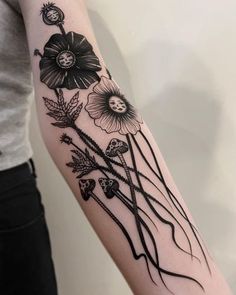 a woman's arm with black and white flowers on the back of her arm