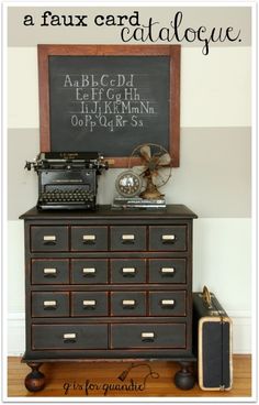 an old fashioned dresser with a chalkboard on the wall above it and a vintage typewriter next to it