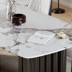 a marble table with a book and cup on it