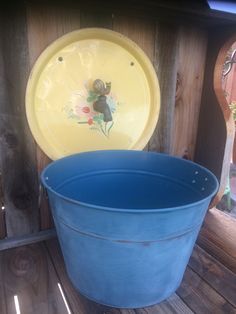 a blue tub sitting on top of a wooden floor next to a yellow plate and bowl