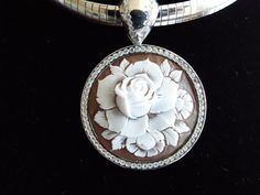 "This is an amazing cameo bezel set in Italian silver with a permanent bail (8mm). The bezel setting and bail have cz's encrusted around the entire rose cameo. It is carved in sardonyx shell and measures 35 mm (1.37\") round. This a beautiful piece to give as a gift or for yourself. It is carved by our carver, Romano. This pendant comes with a 18\" stainless steel chain. This is a rose that will live forever! This pendant comes with a black velvet box and certificate of authenticity. Item Number Luxury Cameo Jewelry, Luxury Silver Cameo Jewelry, Luxury White Gold Cameo Jewelry, Twisted Ribbons, Filigree Pattern, Live Forever, Diamond Settings, Steel Chain, Stainless Steel Chain