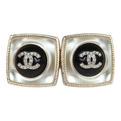 These Chanel Pearl stud earrings in light gold tone hardware, features a square shaped earring with a round black enamel button with the signature CC logo in faux crystals in the center. They also have post back closure.Origin: FranceCondition: Never wornAccompanied by: Chanel boxMeasurements: .75" x .75" Luxury Metal Clip-on Earrings For Evening, Luxury Square Earrings For Formal Occasions, Designer Metal Clip-on Earrings For Formal Occasions, Luxury Metal Clip-on Earrings, Chanel Jewellery, Chanel Pearl, Chanel Pearls, Chanel Jewelry, Madison Avenue