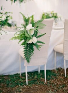 the table is set with white flowers and greenery