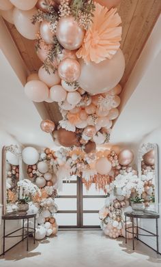 a room filled with balloons and flowers hanging from the ceiling