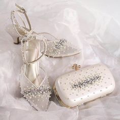 two pairs of shoes and a purse on a white cloth