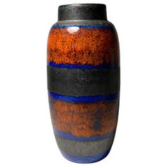 an orange and black vase with blue stripes on the outside, against a white background