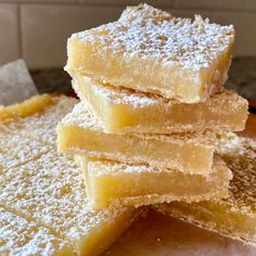 several pieces of cake are stacked on top of each other with powdered sugar toppings