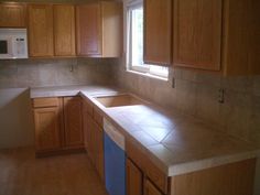 a kitchen with wooden cabinets and tile counter tops