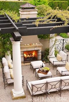 an outdoor patio with white furniture and a fireplace