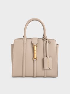 This product is made with at least 20% sustainable materials by weight. CHARLES & KEITH uses recycled, degradable, organic, and water-based materials in our eco-conscious collection.A classic top-handle bag is always the polished choice. This iteration features a classic rectangular silhouette, with the addition of a distinctive metallic accent that also doubles as a magnetic closure. Opening up to a roomy interior, it will fit your everyday essentials while looking sophisticated with the taupe Luxury Taupe Shoulder Bag For Business, Luxury Taupe Tote Bag, Luxury Versatile Taupe Bag, Luxury Taupe Workwear Bags, Luxury Taupe Elegant Shoulder Bag, Luxury Taupe Office Bag, Luxury Taupe Double Handle Bag, Luxury Taupe Bag With Leather Handles, Luxury Taupe Bag With Gold-tone Hardware