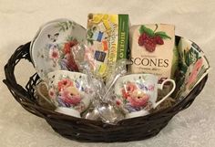 a wicker basket filled with tea cups and saucers next to books on a table